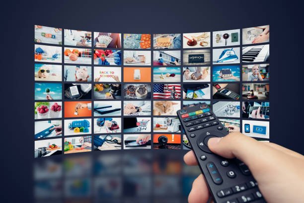 multimedia video wall television broadcast. hand holding remote control.